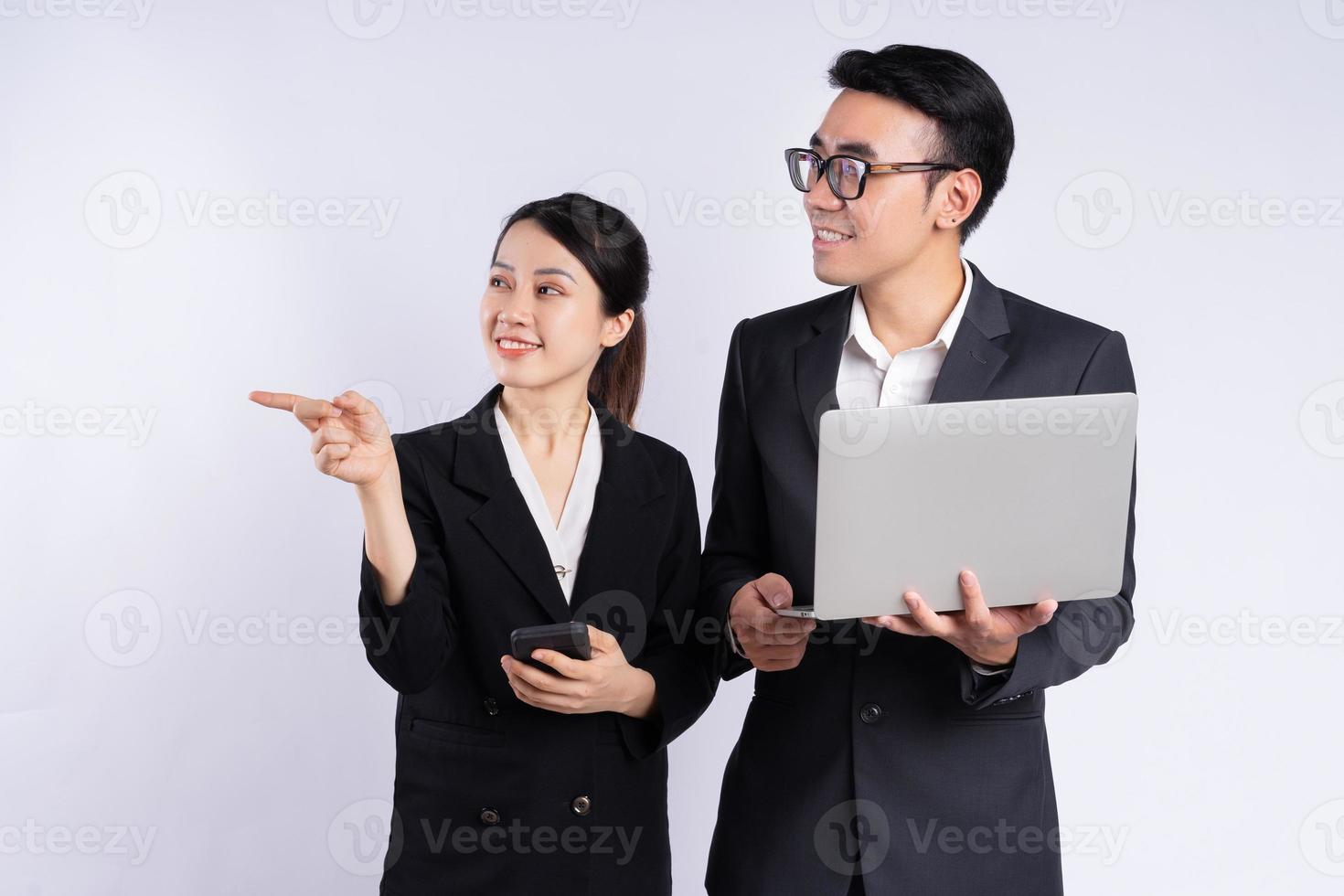 Asian businessman and businesswoman using laptop on white background photo