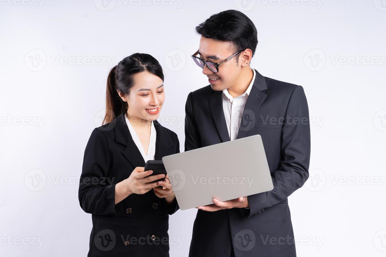 Empresario asiático y empresaria con portátil sobre fondo blanco. foto