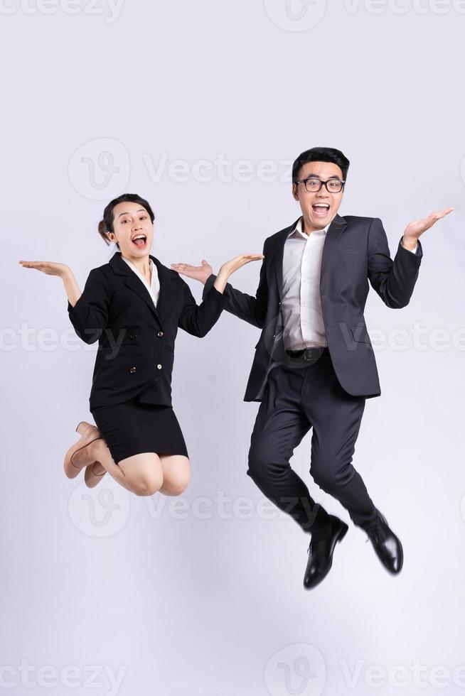 Businessman and business woman jumping on white background photo