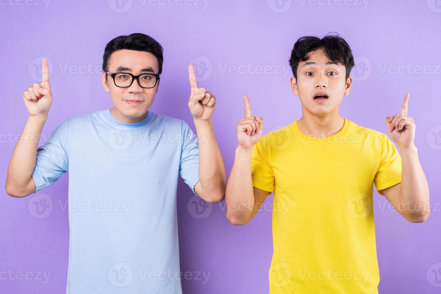 dos hermanos asiáticos posando sobre fondo púrpura foto