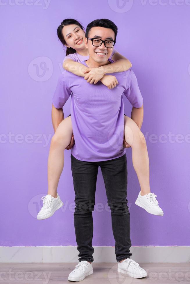 joven pareja asiática posando sobre fondo púrpura foto