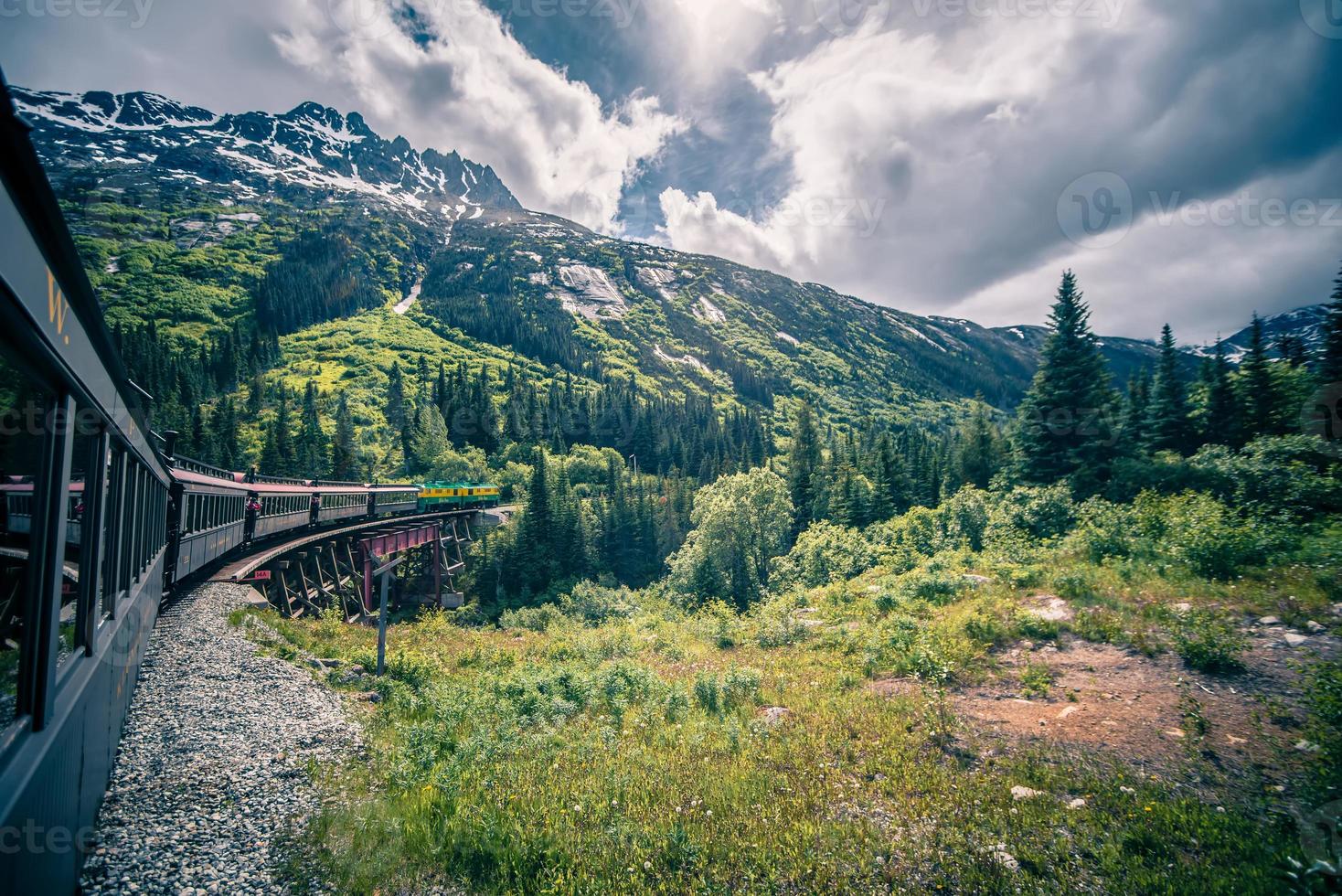 el paso blanco y la ruta del yukón en tren que pasa por un vasto paisaje foto