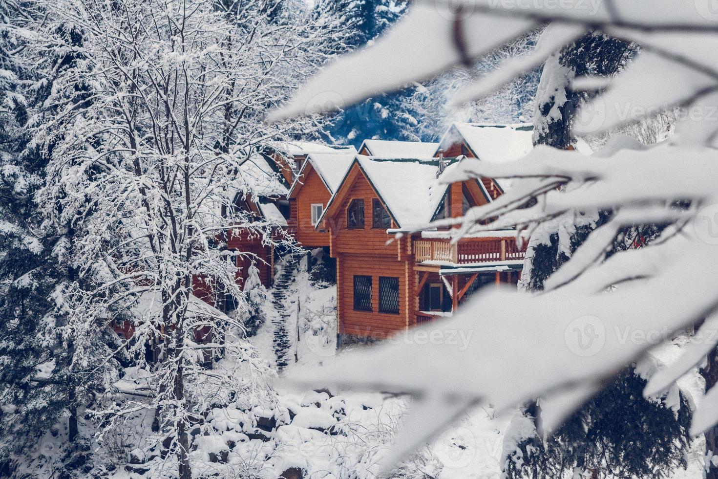 Wooden cottage house in mountain covered with fresh snow in winter photo