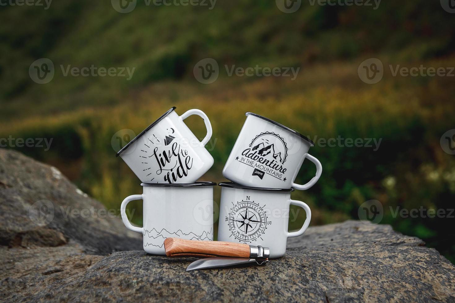 Metal cups with a tourist knife on the rock in the nature photo