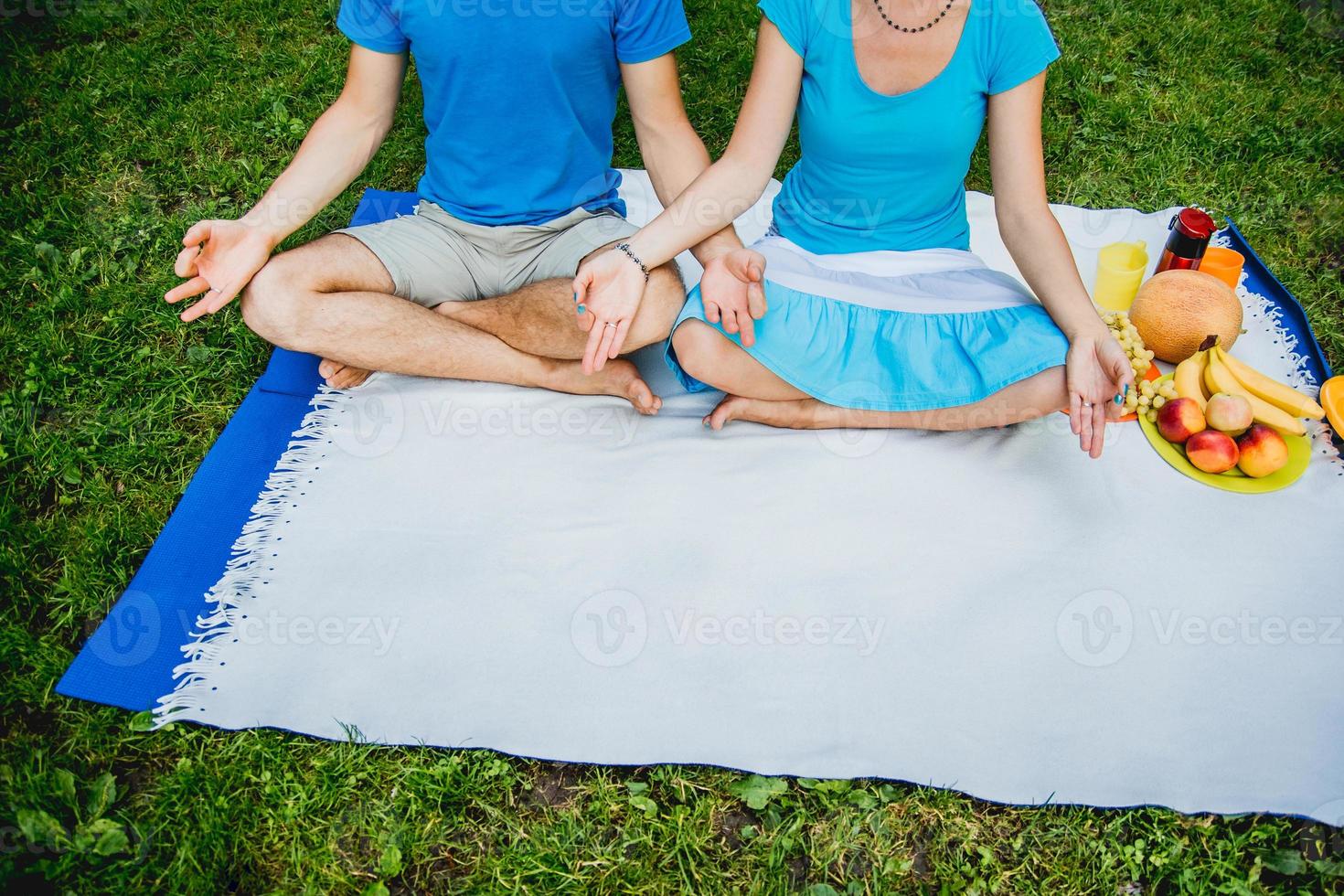 Young couple sitting in a meditative pose relaxing in nature photo