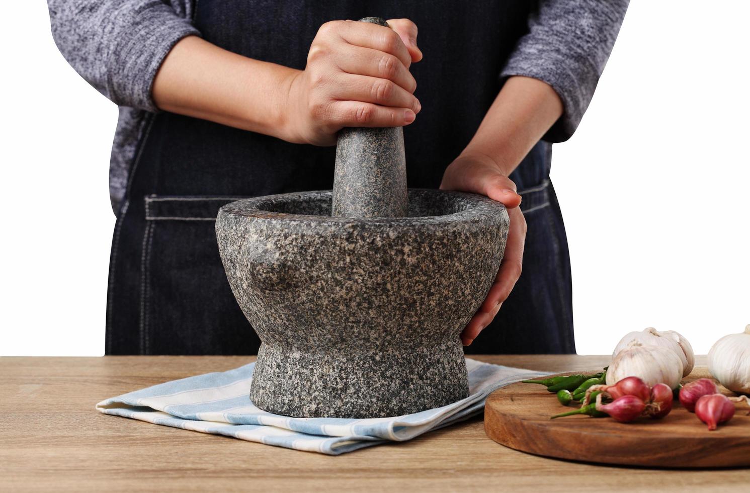 Woman use stone Mortar and Pestle for cooking green curry paste photo