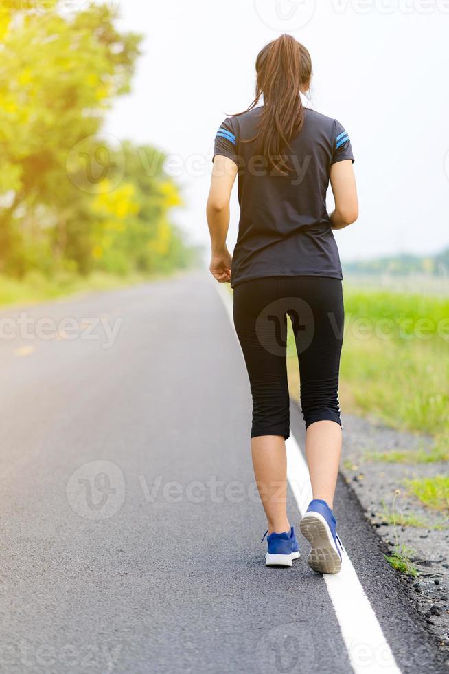 hermosa niña corriendo en la carretera, entrenamiento de mujer fitness saludable foto
