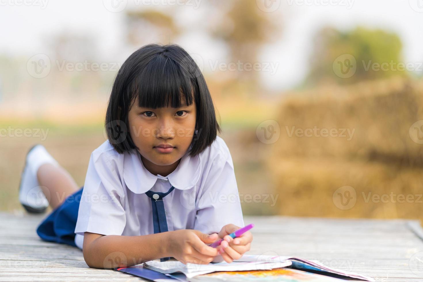 Estudiante asiático en uniforme estudiando en la campiña de Tailandia foto