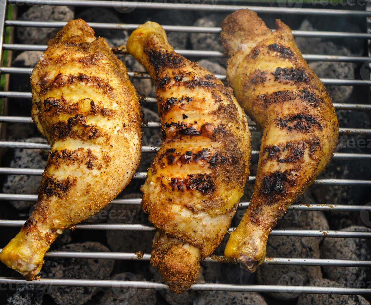 Spicy chicken drumsticks on the grill photo