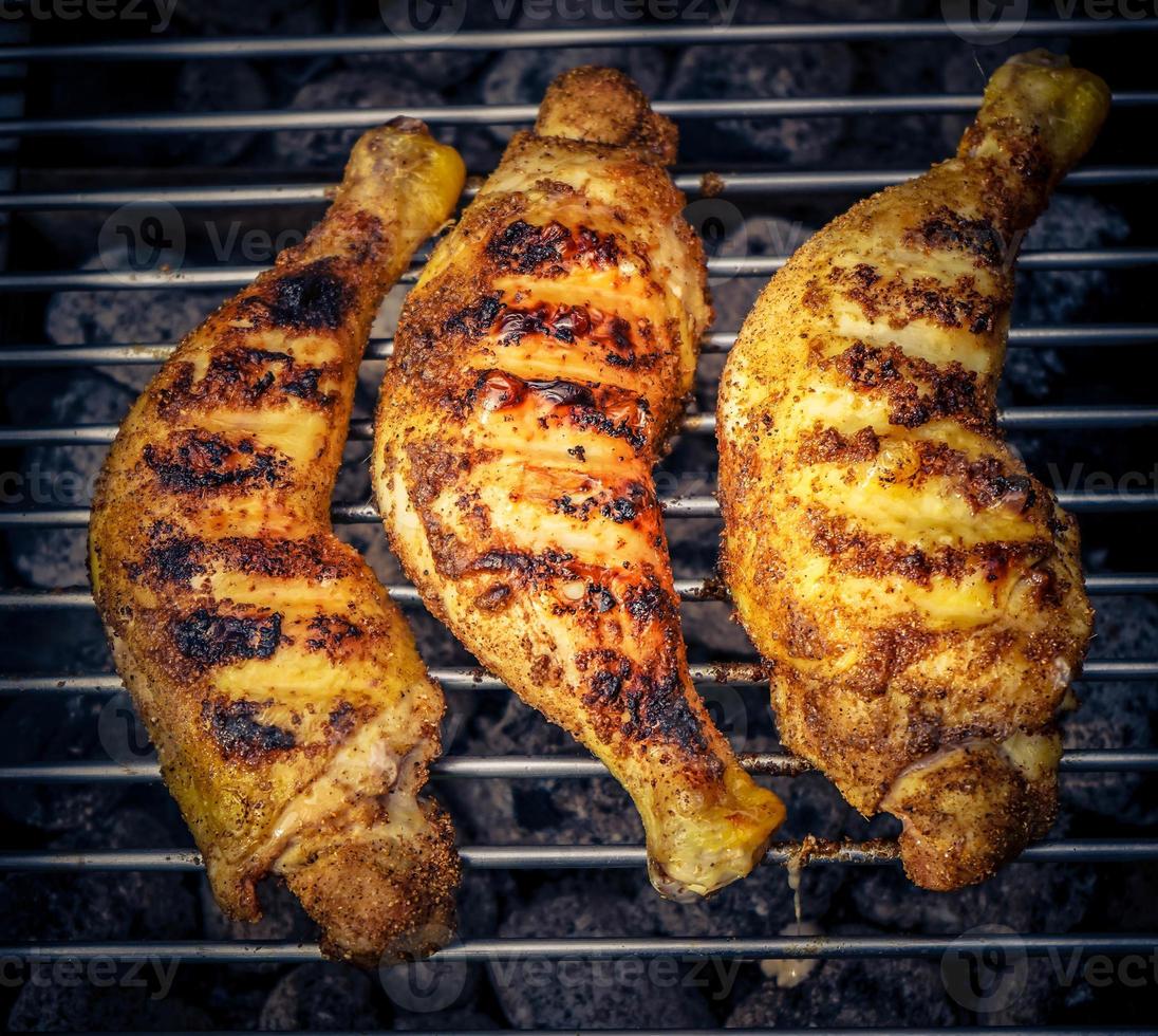 Spicy chicken drumsticks on the grill photo