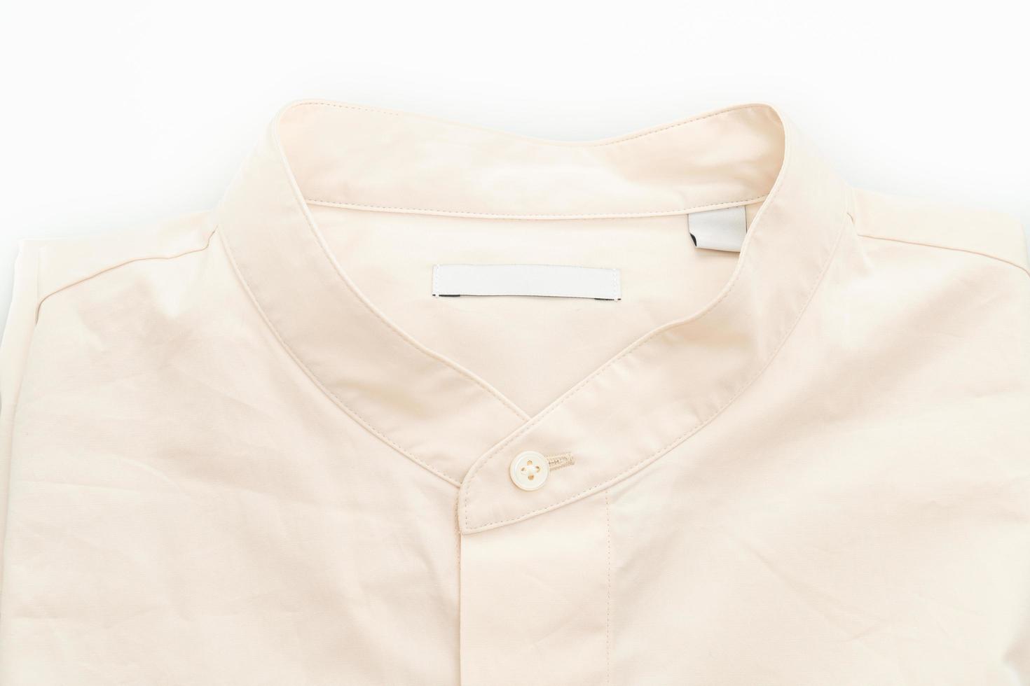 Camisa beige doblada aislado sobre fondo blanco. foto