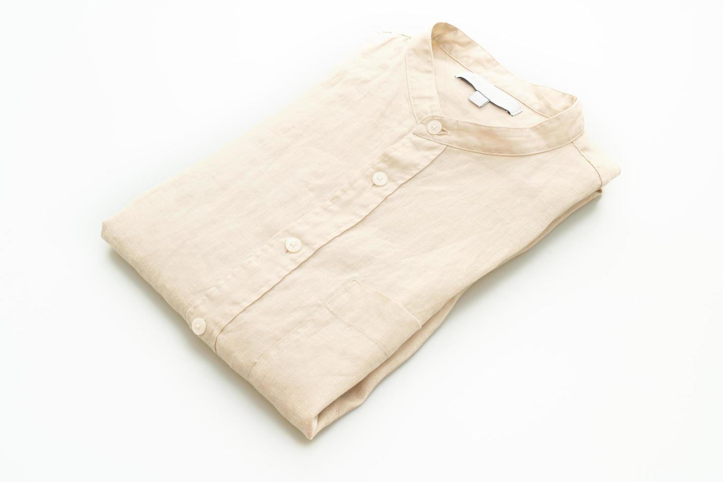 Camisa beige doblada aislado sobre fondo blanco. foto