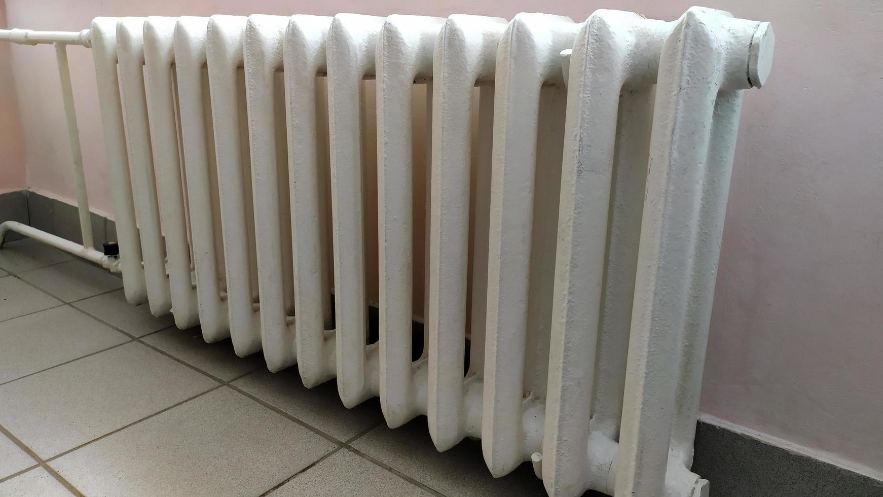 Indoor heating radiator. Cast iron radiators heat the room. photo