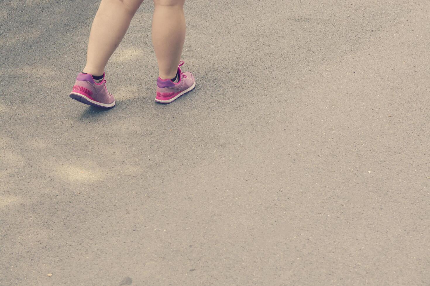 Fat woman legs walking in sports shoes photo