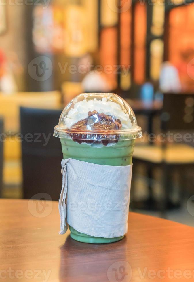 Iced green tea with whipped cream and red bean in cafe photo