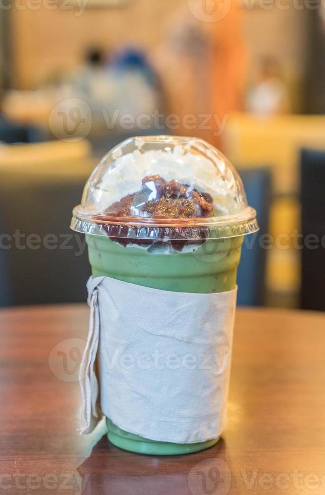 Iced green tea with whipped cream and red bean in cafe photo