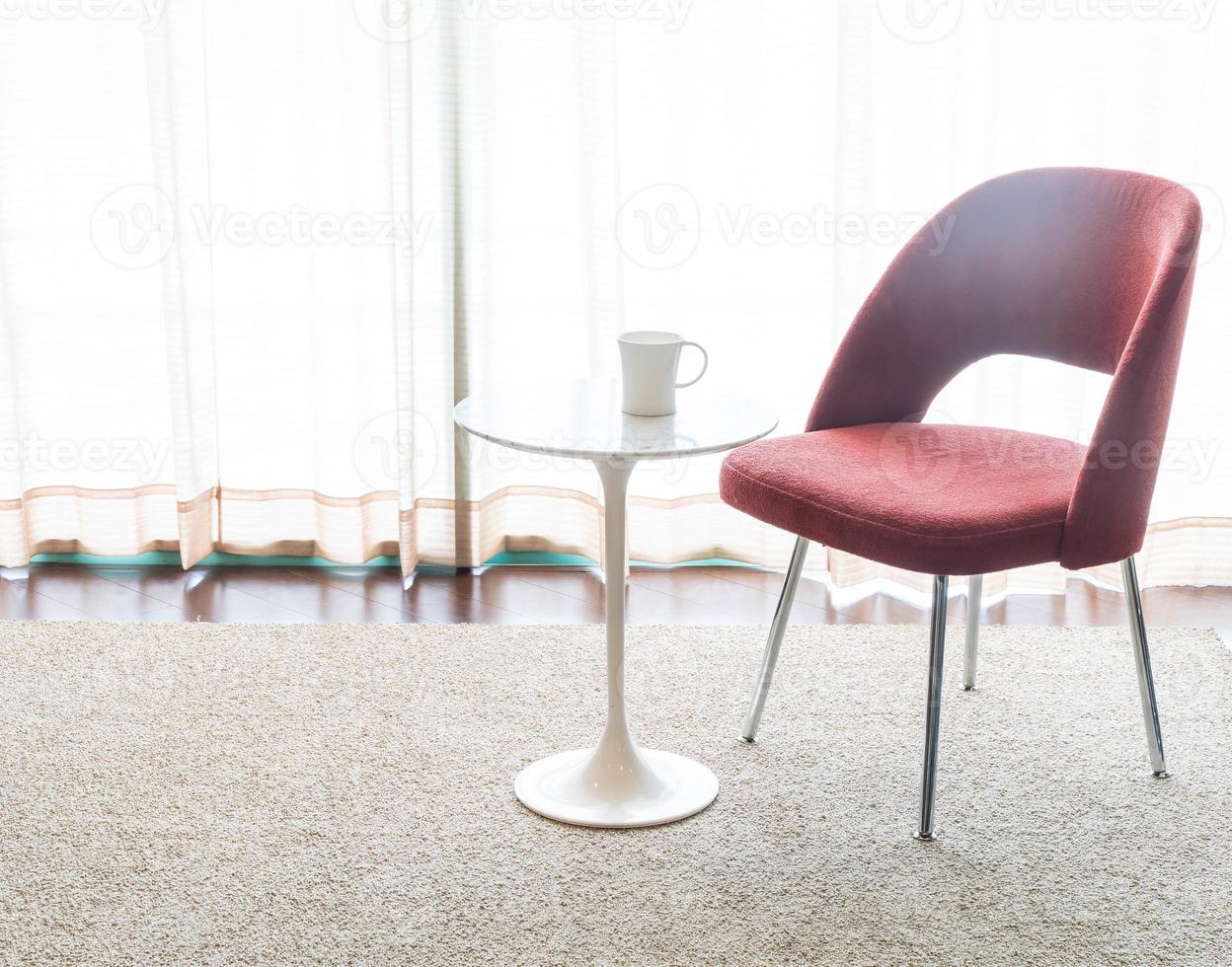 Taza de café con una hermosa decoración de sillas y mesas de lujo en el interior de la sala de estar para el fondo - filtro vintage foto