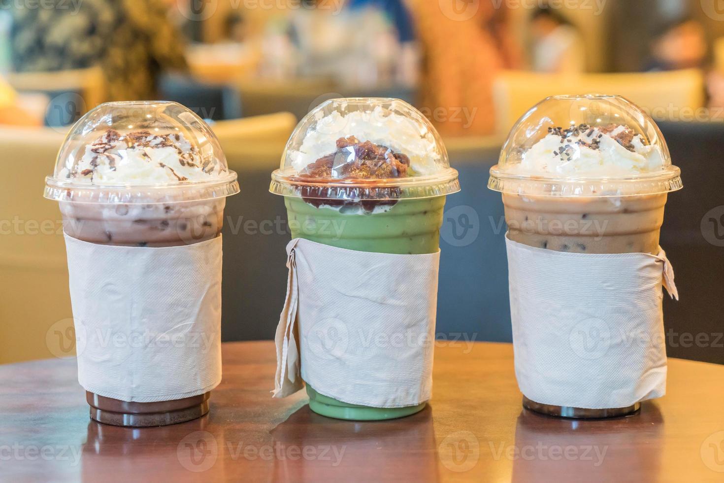 Iced Green Tea, Iced Chocolate, and Iced Coffee with whipped cream in a cafe photo