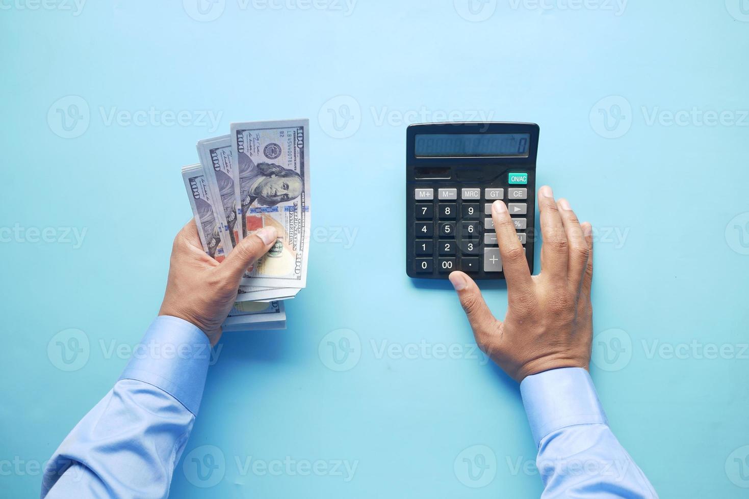 man hand using calculator and holding us dollar cash photo