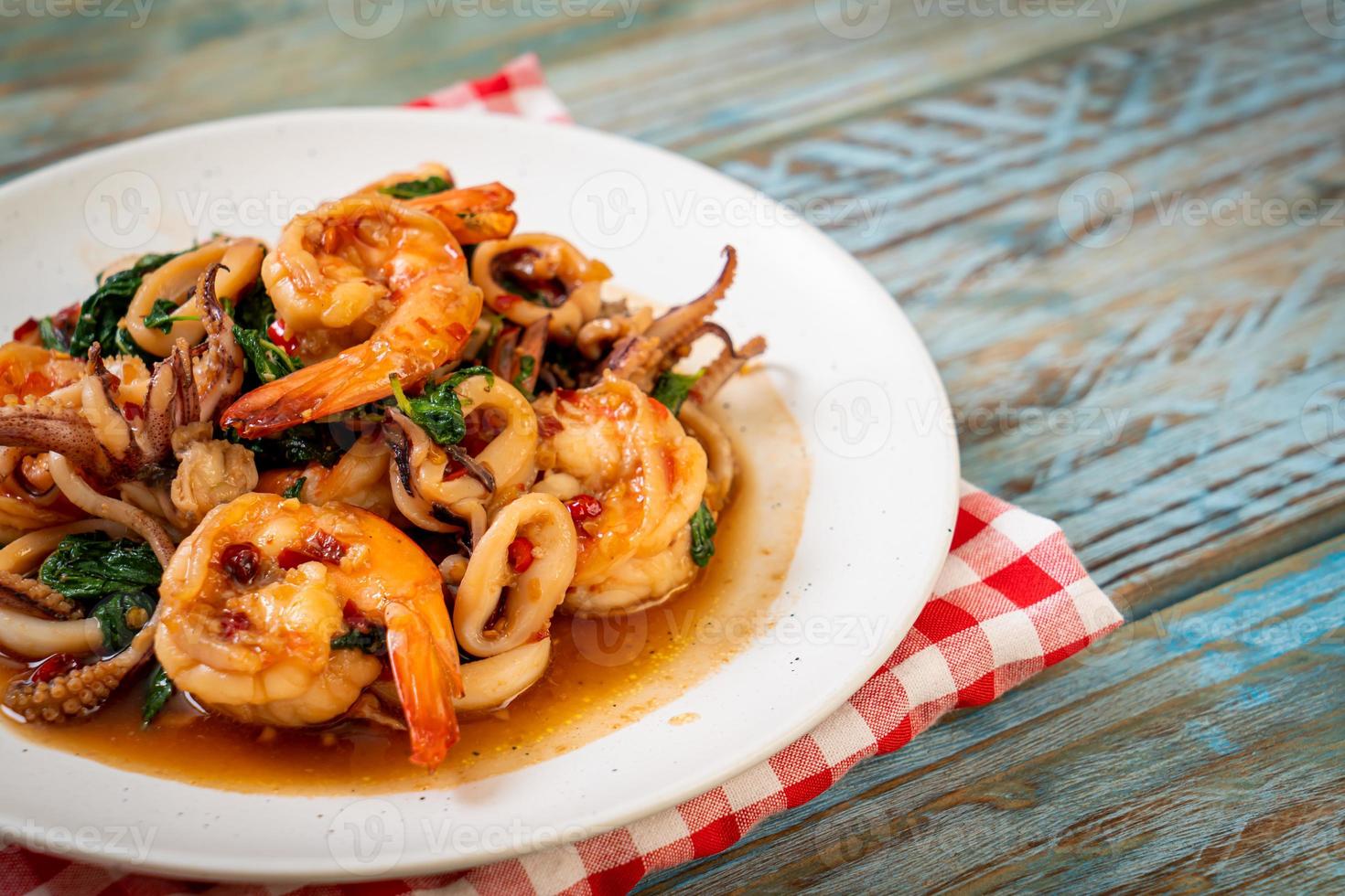 mariscos salteados de camarones y calamares con albahaca tailandesa - estilo de comida asiática foto