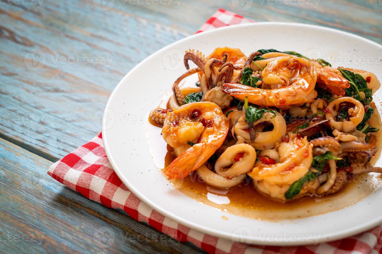 mariscos salteados de camarones y calamares con albahaca tailandesa - estilo de comida asiática foto