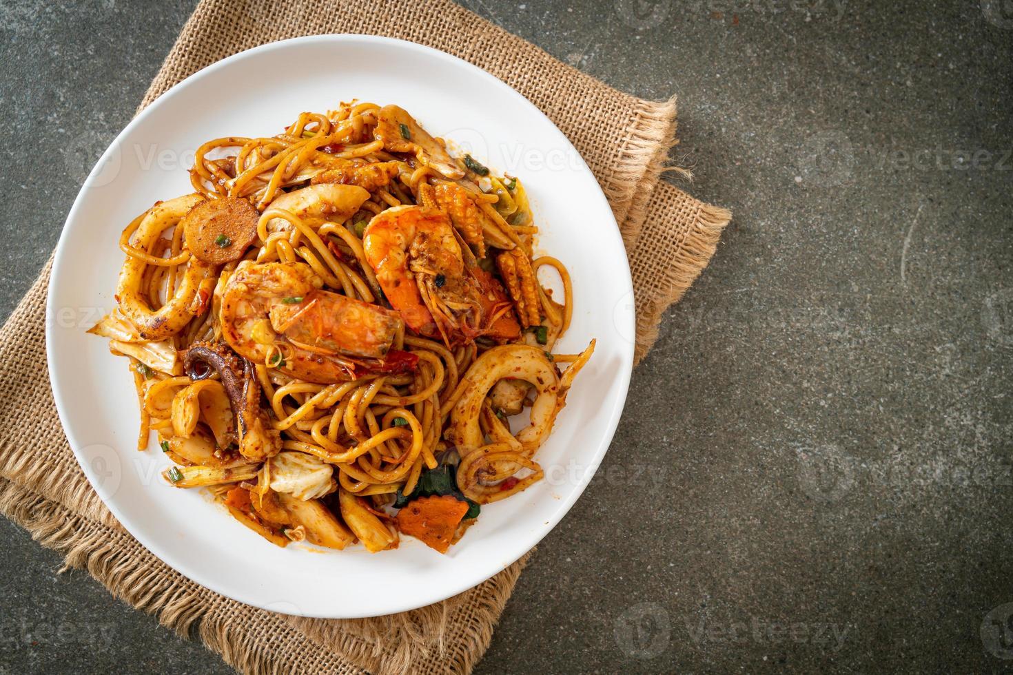 espaguetis secos con mariscos salteados tom yum - estilo de comida fusión foto