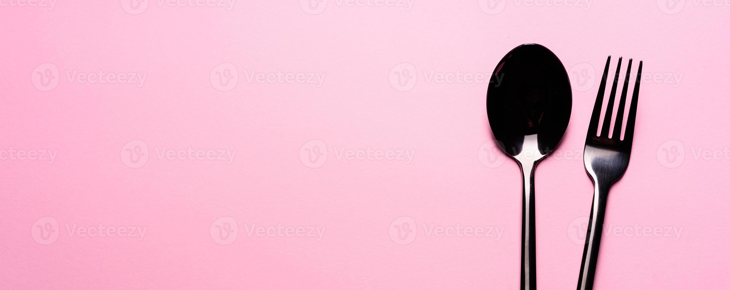 Metal Spoon and fork Isolated on pink background photo