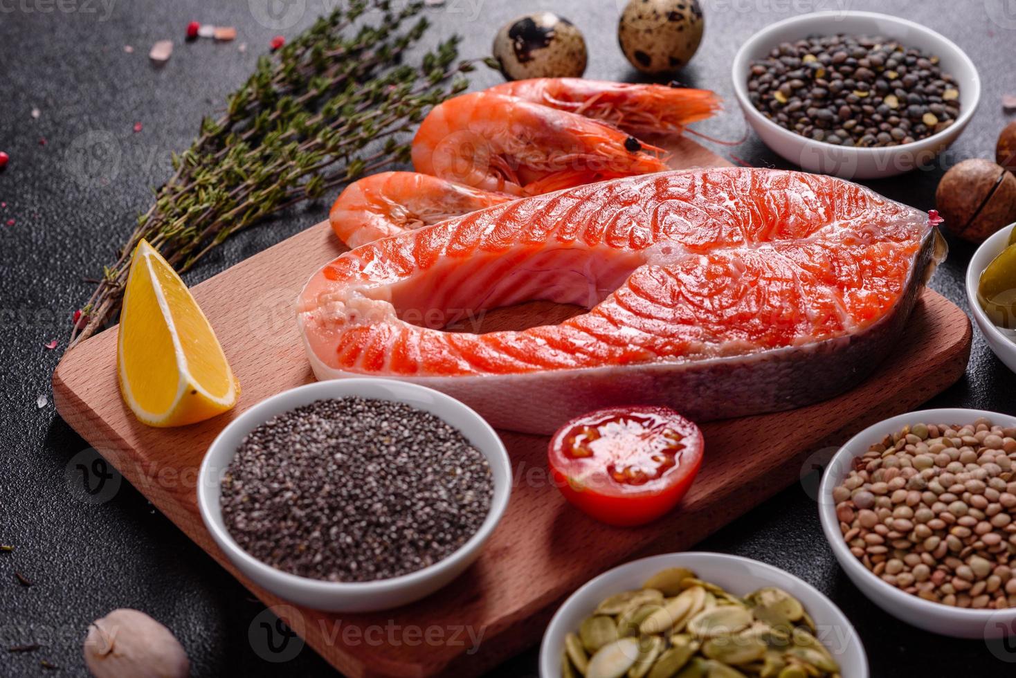 Filete de pescado rojo trucha cruda servido con hierbas y limón foto