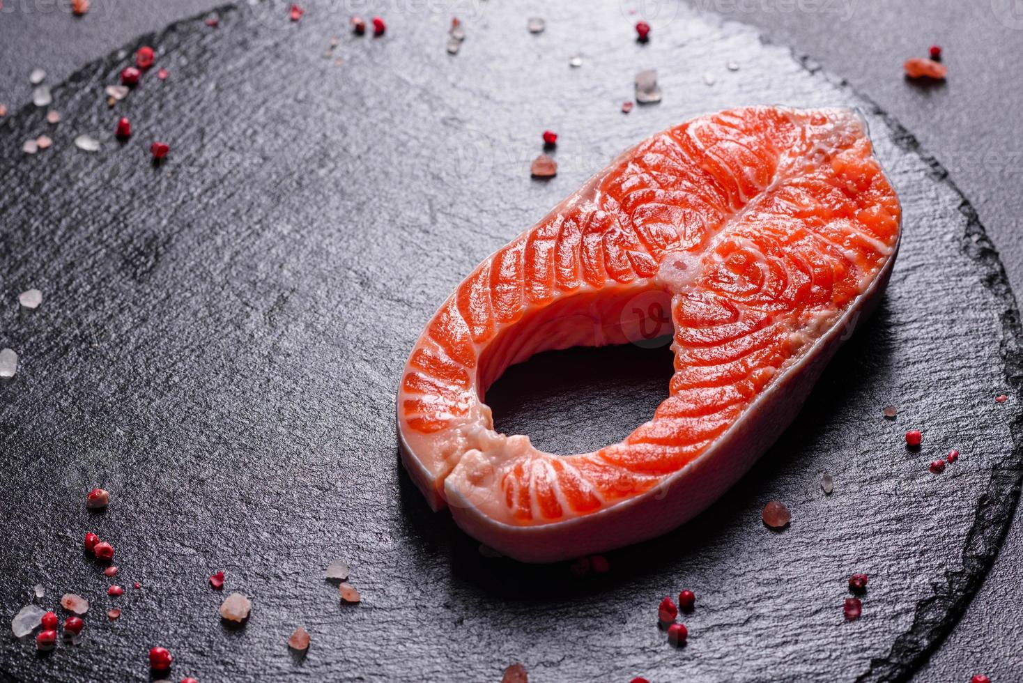 Filete de pescado rojo trucha cruda servido con hierbas y limón foto