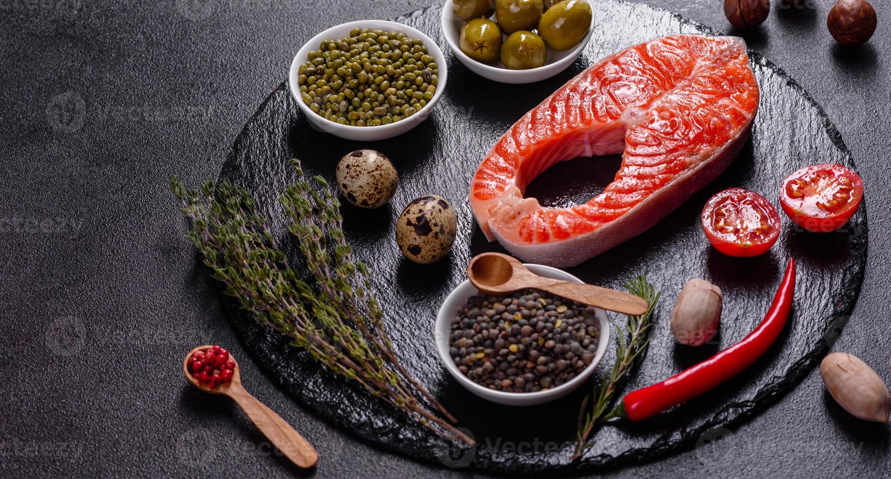 Filete de pescado rojo trucha cruda servido con hierbas y limón foto