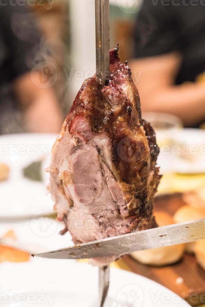 Slicing steak Brazillian style on plate photo