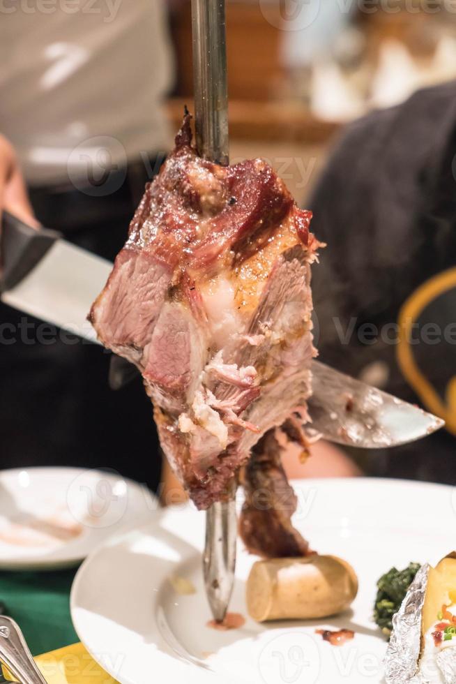 Slicing steak Brazillian style on plate photo