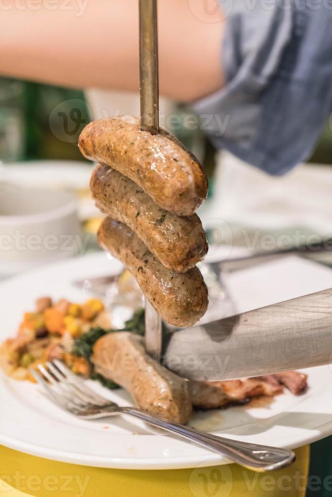 Slicing steak Brazillian style on plate photo