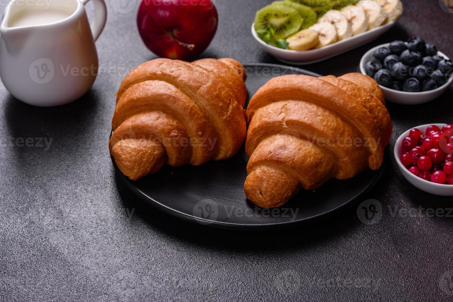 Delicious breakfast with fresh croissants and ripe berries photo