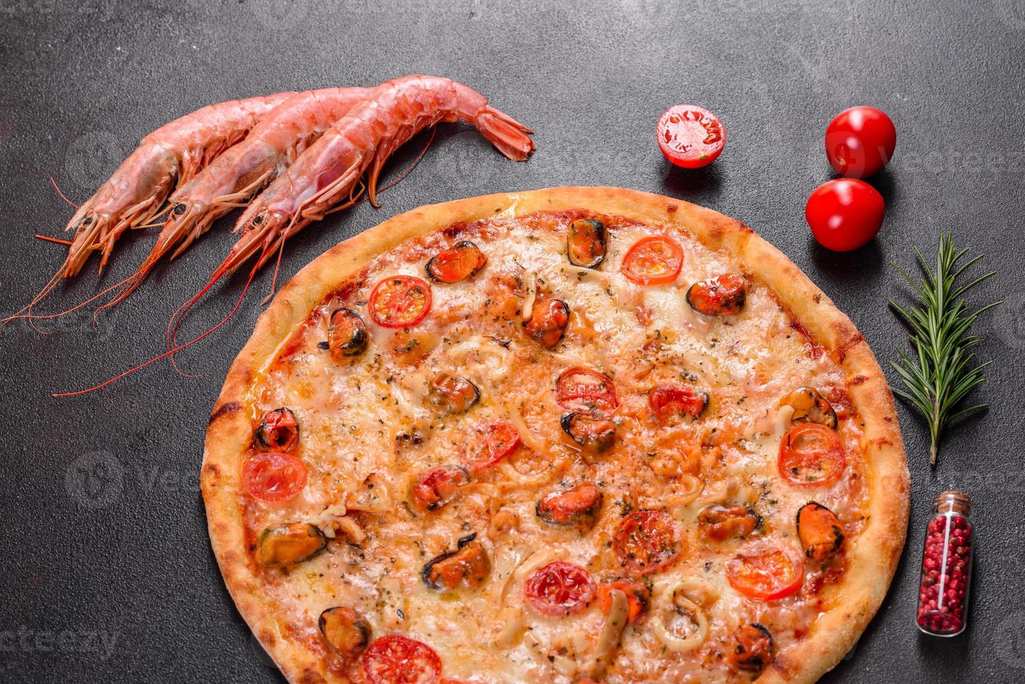 Tasty sliced pizza with seafood and tomato on a concrete background photo