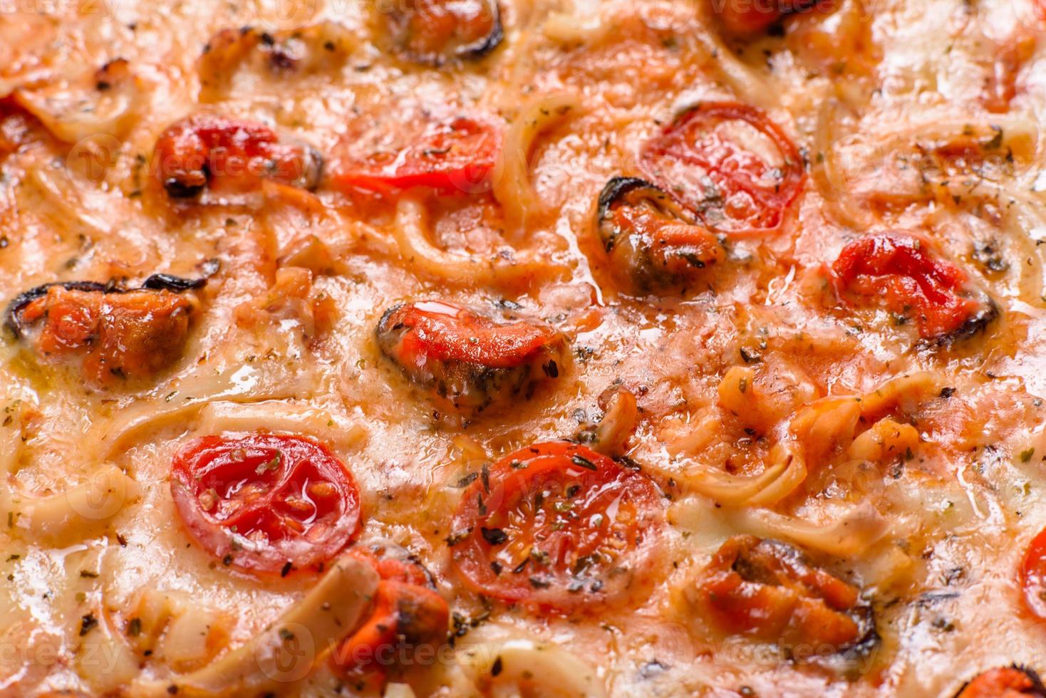 Tasty sliced pizza with seafood and tomato on a concrete background photo