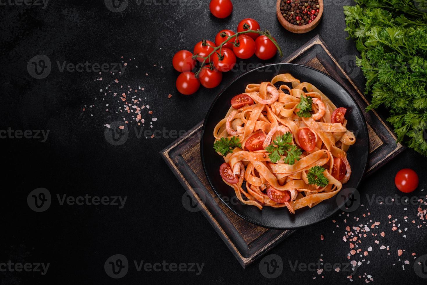 Fettuccine pasta with shrimp, cherry tomatoes, sauce, spices and herbs photo