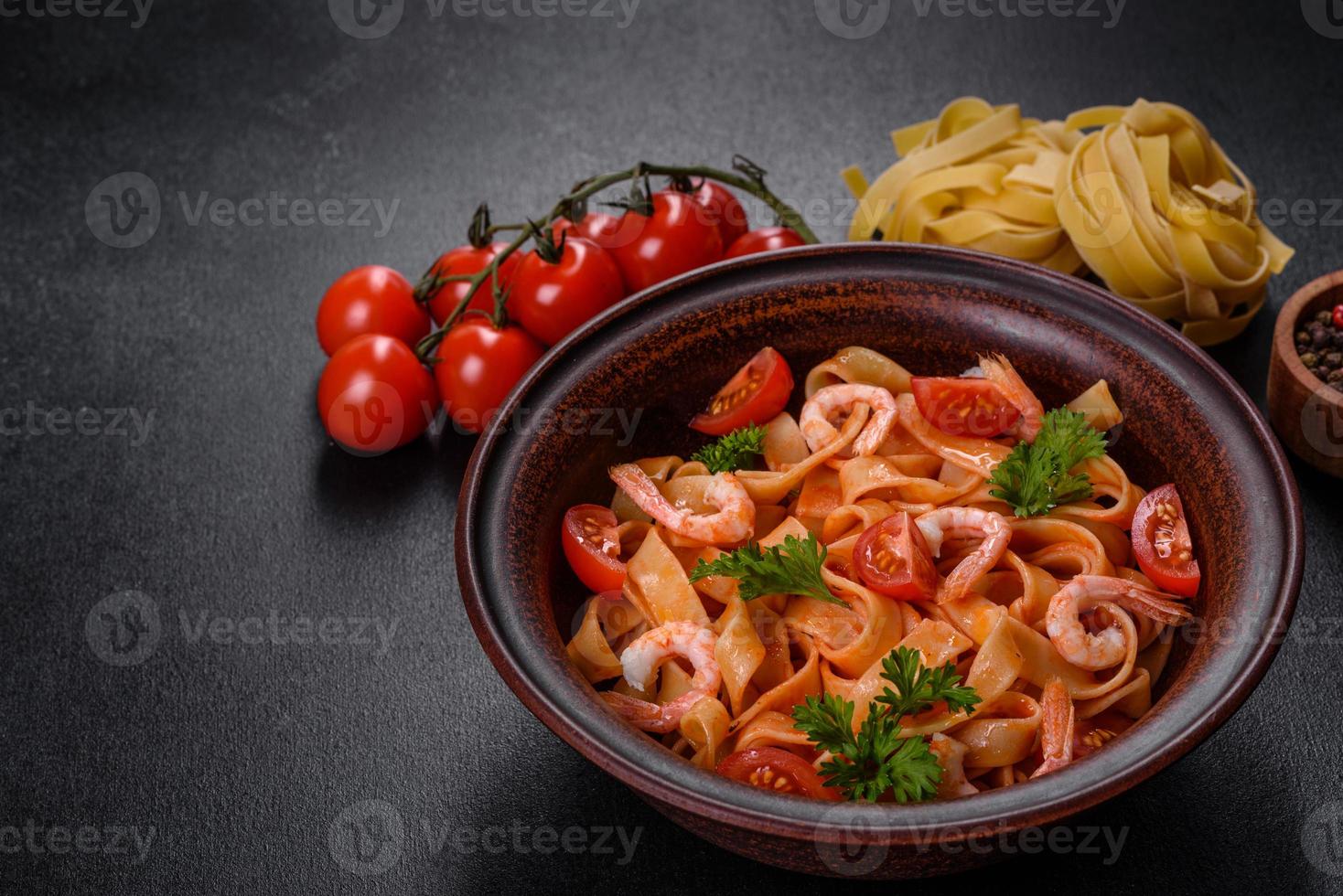 Fettuccine pasta with shrimp, cherry tomatoes, sauce, spices and herbs photo