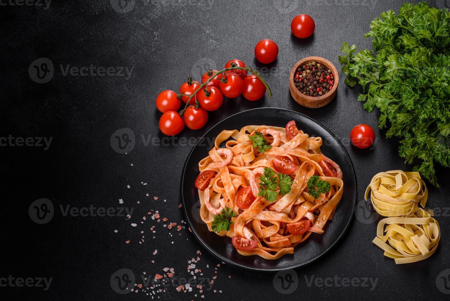 pasta fettuccine con camarones, tomates cherry, salsa, especias y hierbas foto