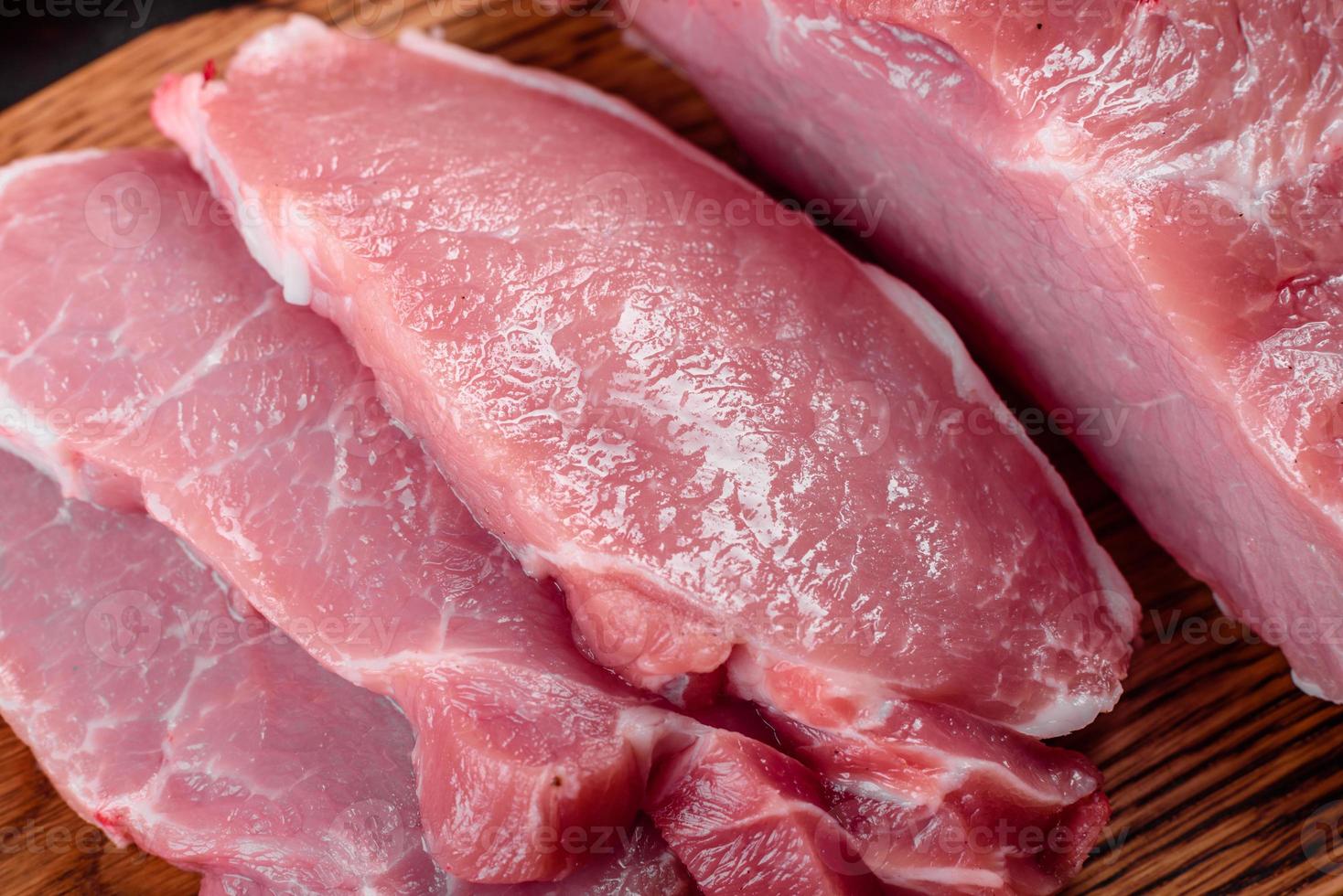 Piezas frescas de cerdo listas para cocinar sobre un fondo oscuro en la cocina foto