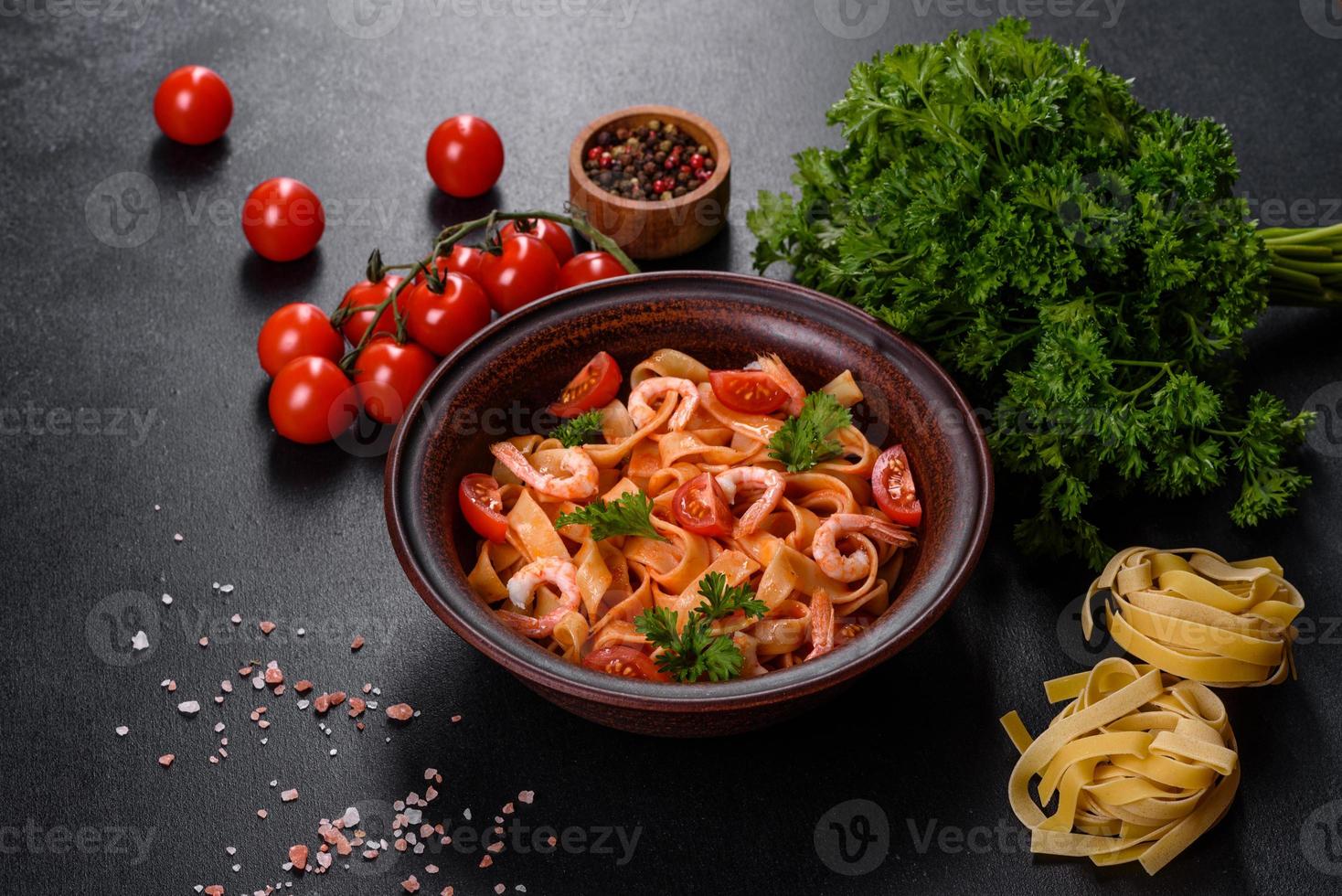 Fettuccine pasta with shrimp, cherry tomatoes, sauce, spices and herbs photo