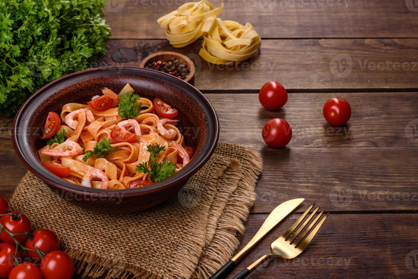 Fettuccine pasta with shrimp, cherry tomatoes, sauce, spices and herbs photo