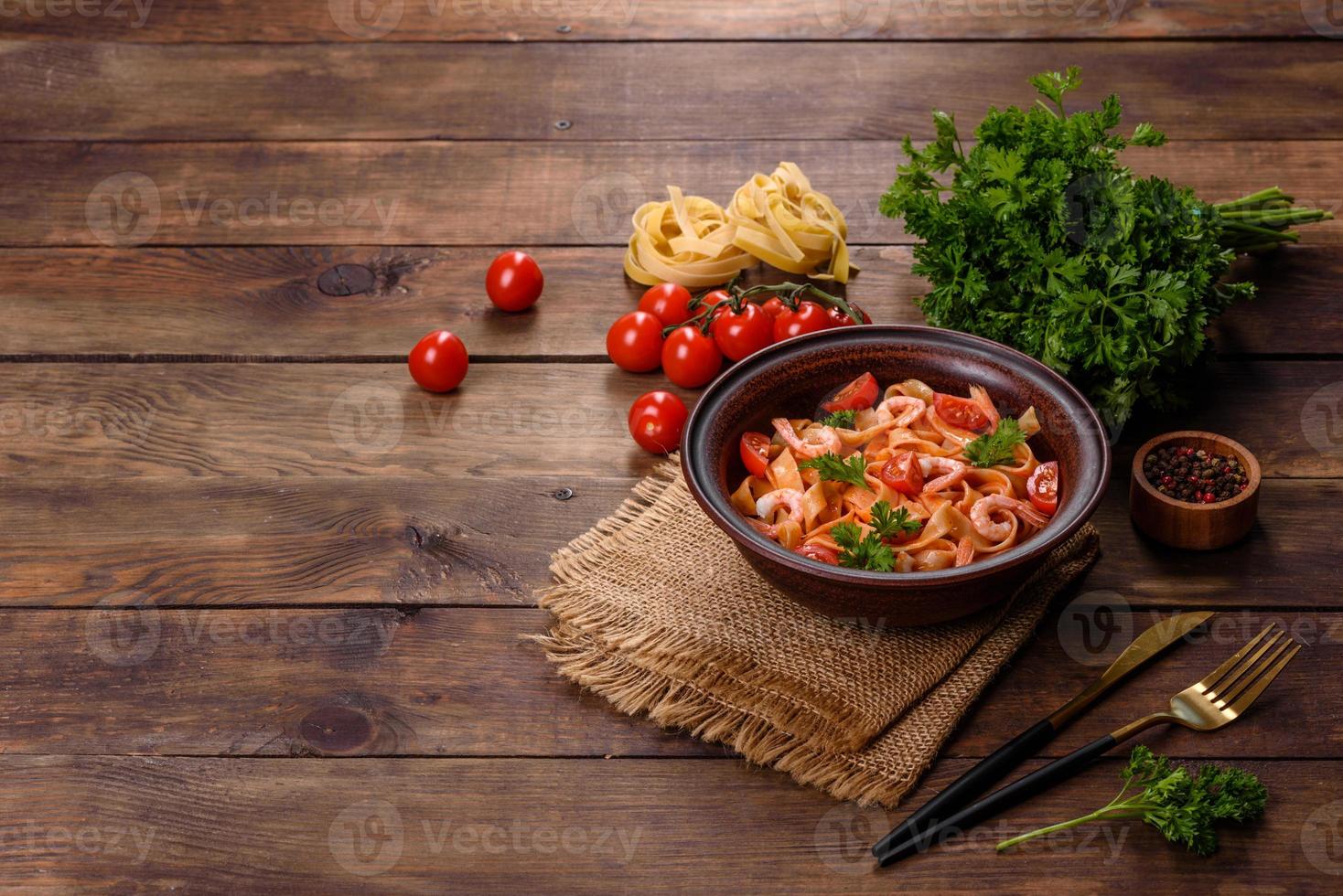 Fettuccine pasta with shrimp, cherry tomatoes, sauce, spices and herbs photo