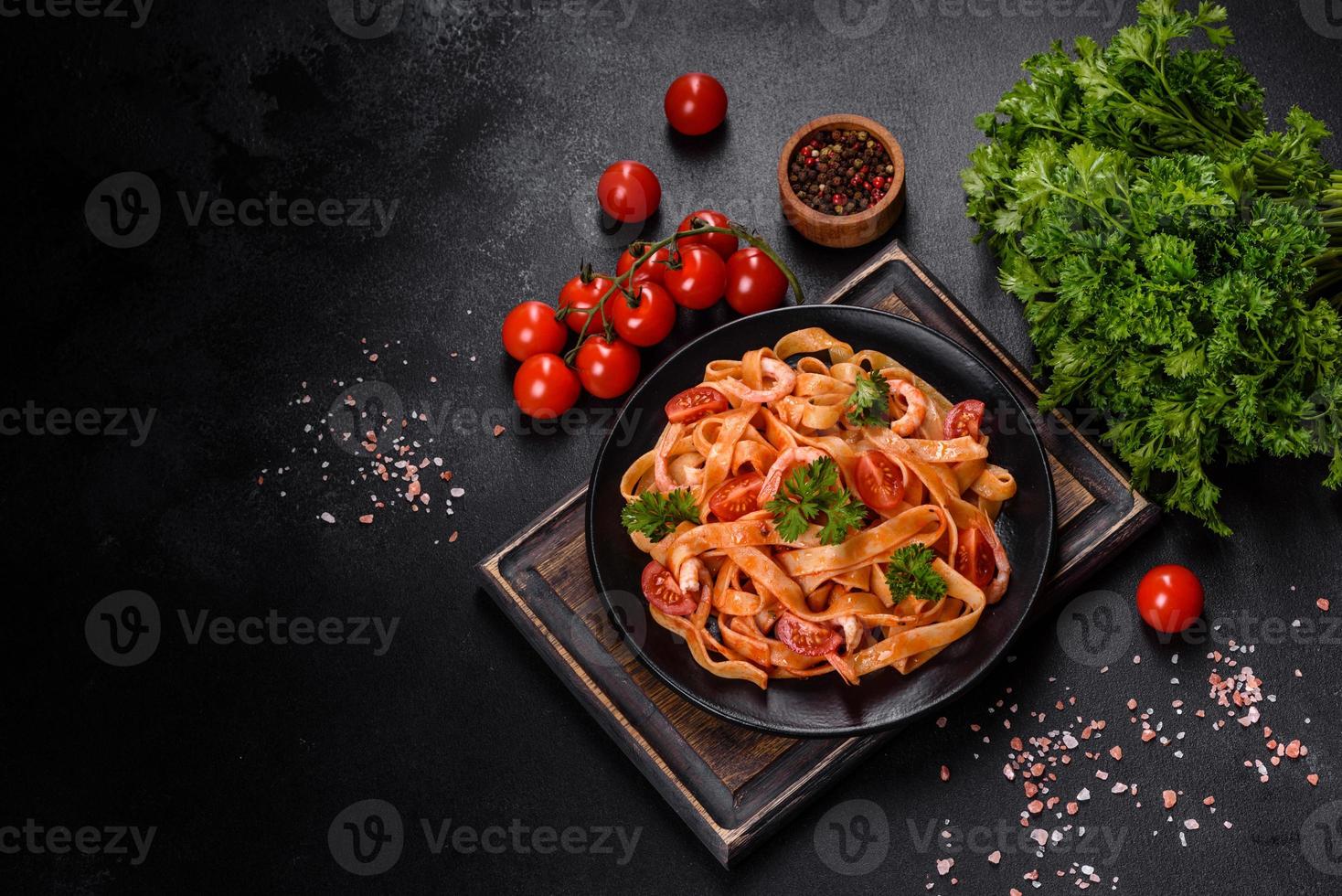 pasta fettuccine con camarones, tomates cherry, salsa, especias y hierbas foto