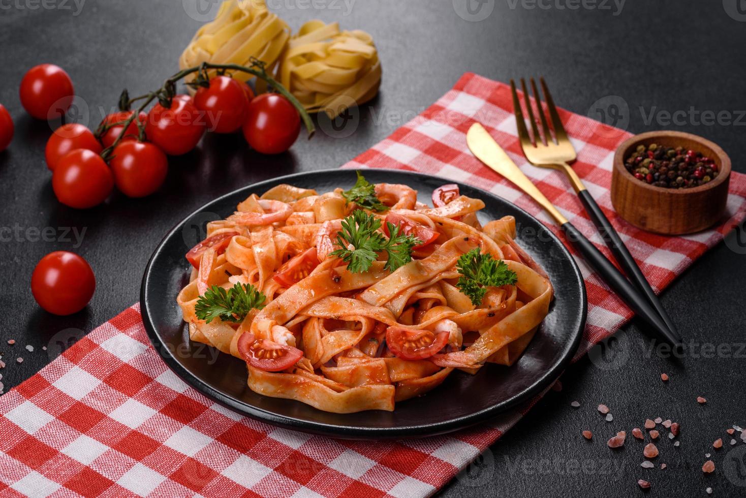 Fettuccine pasta with shrimp, cherry tomatoes, sauce, spices and herbs photo