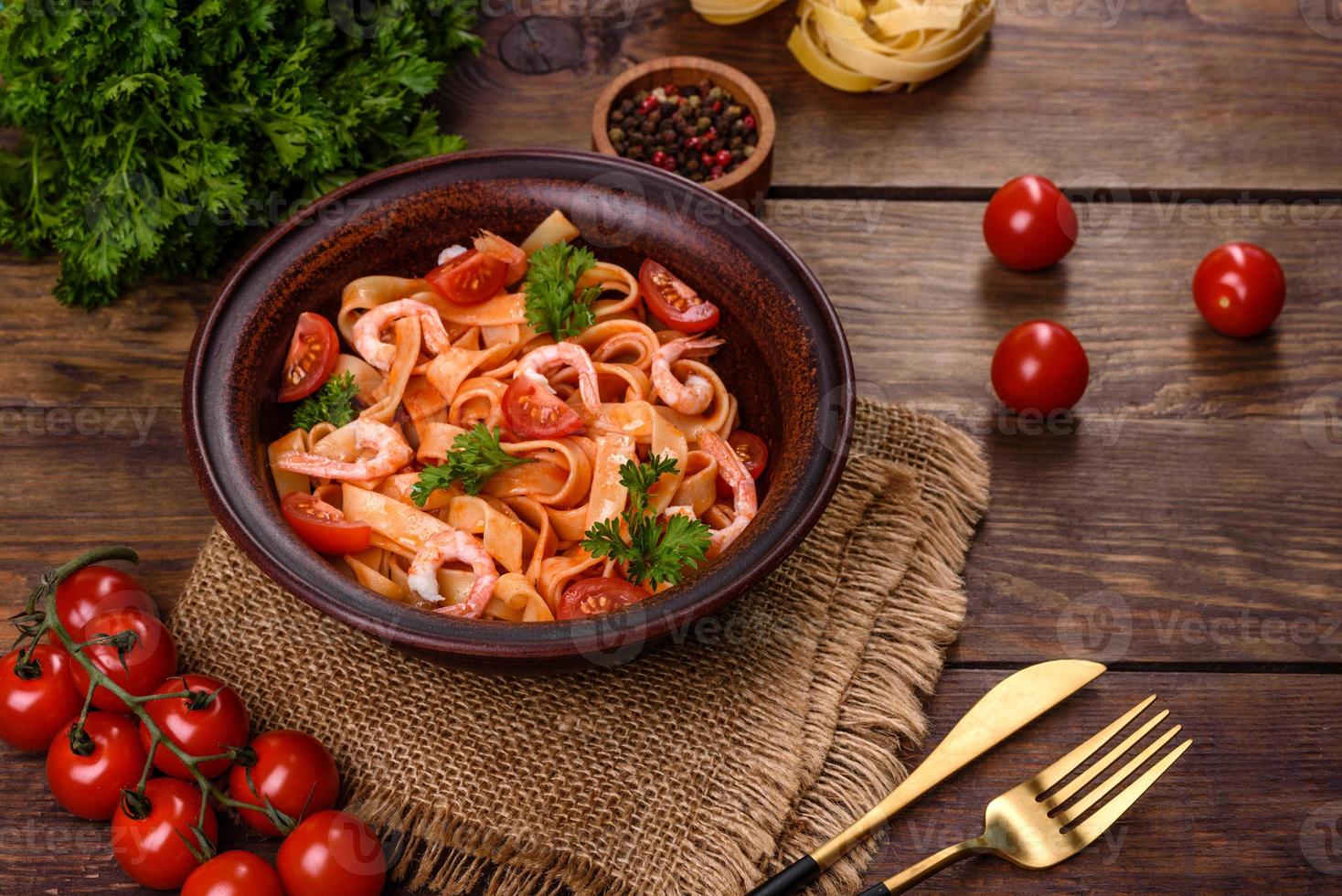 pasta fettuccine con camarones, tomates cherry, salsa, especias y hierbas foto