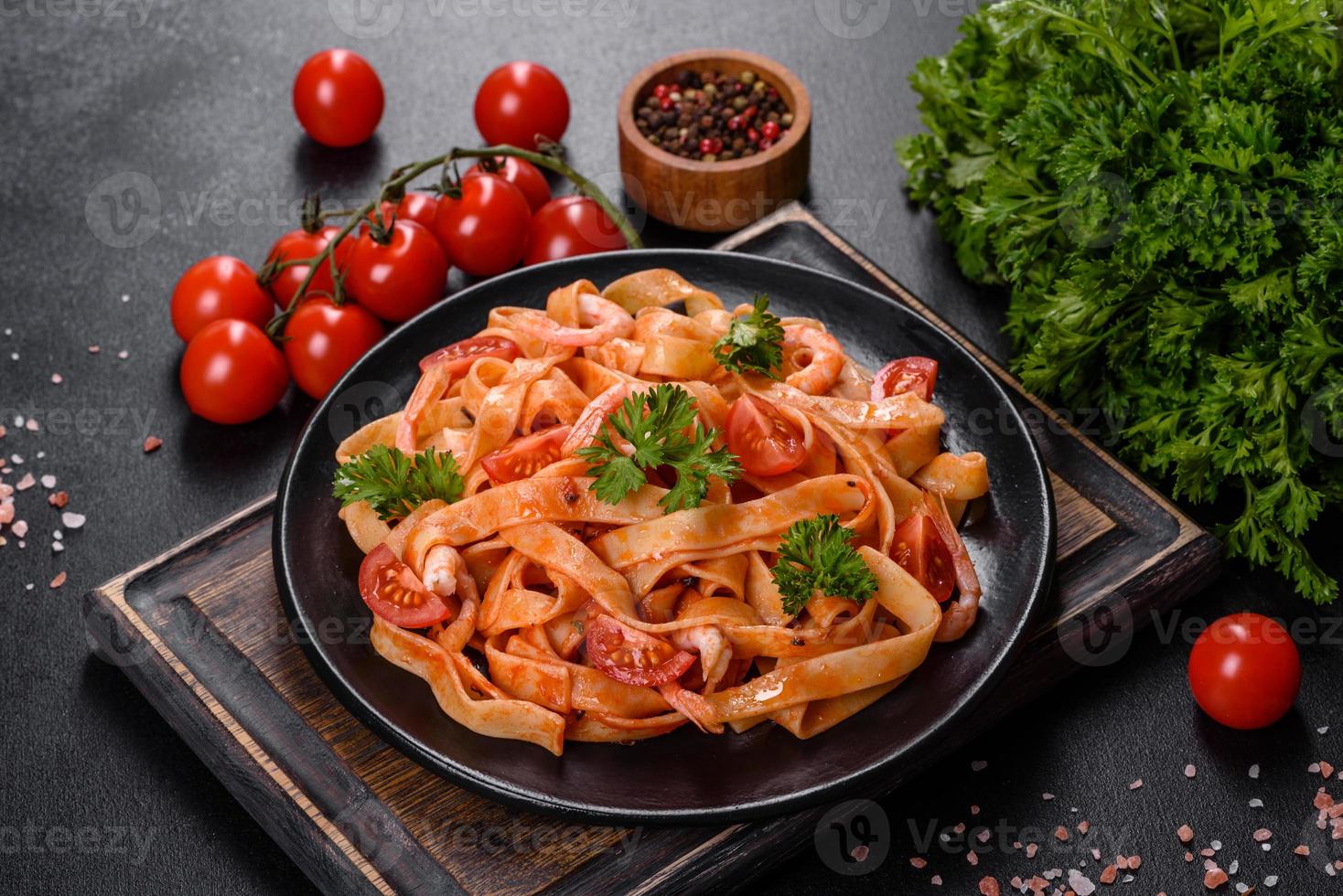 Fettuccine pasta with shrimp, cherry tomatoes, sauce, spices and herbs photo