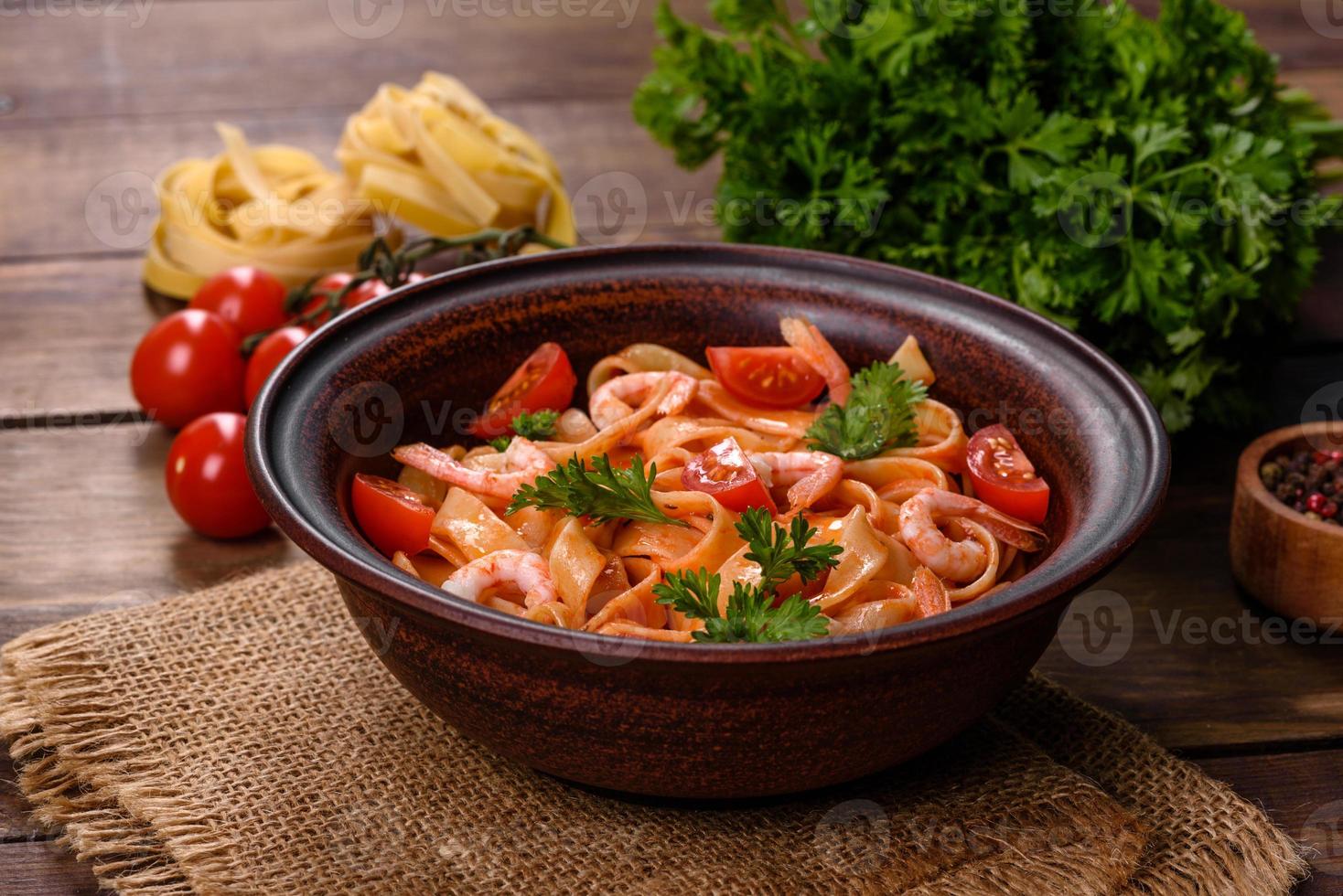 Fettuccine pasta with shrimp, cherry tomatoes, sauce, spices and herbs photo