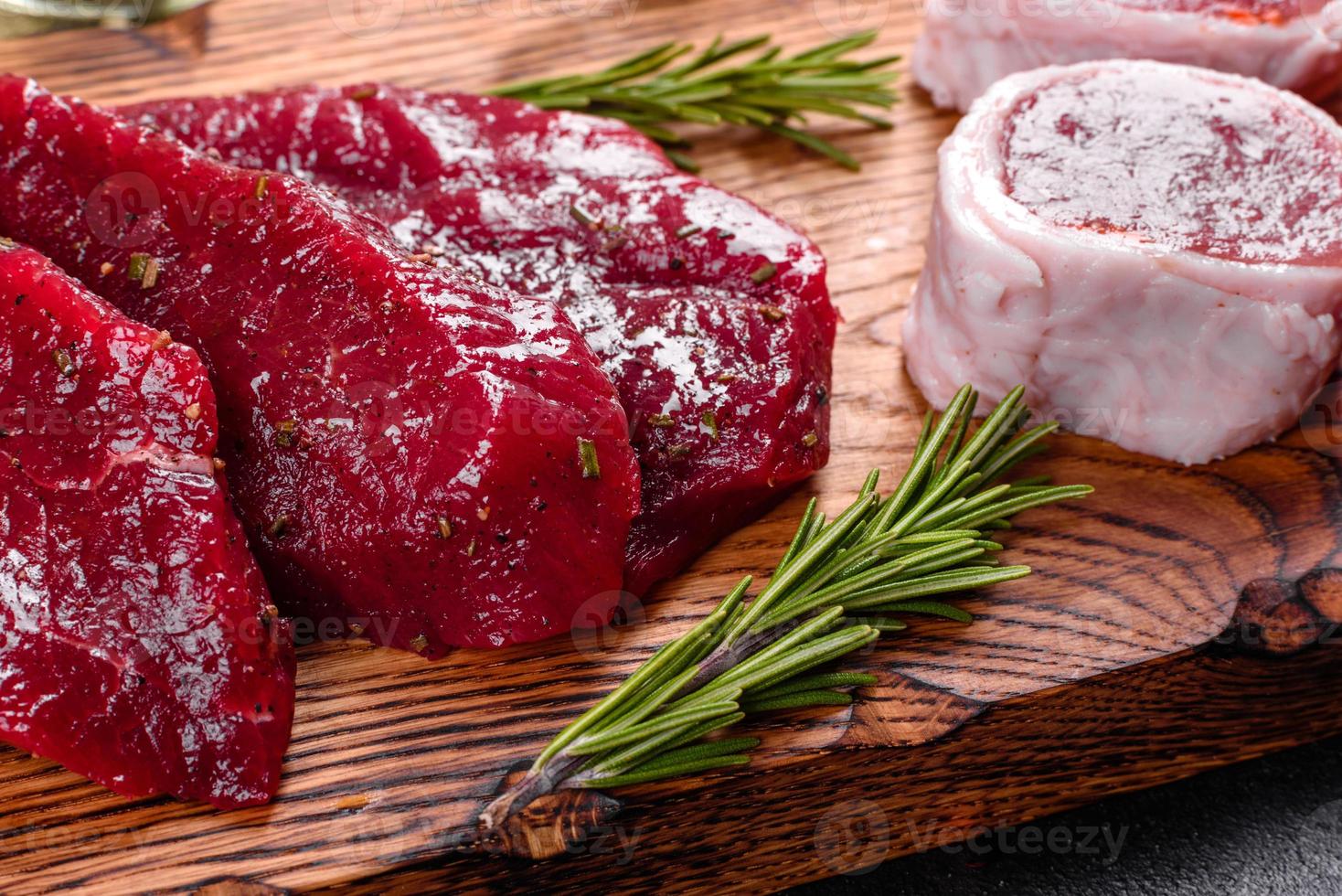 Filete de ternera cruda fresca mignon, con sal, granos de pimienta foto