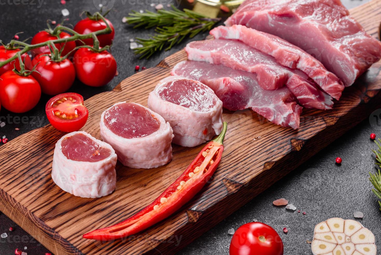 Piezas frescas de cerdo listas para cocinar sobre un fondo oscuro en la cocina foto